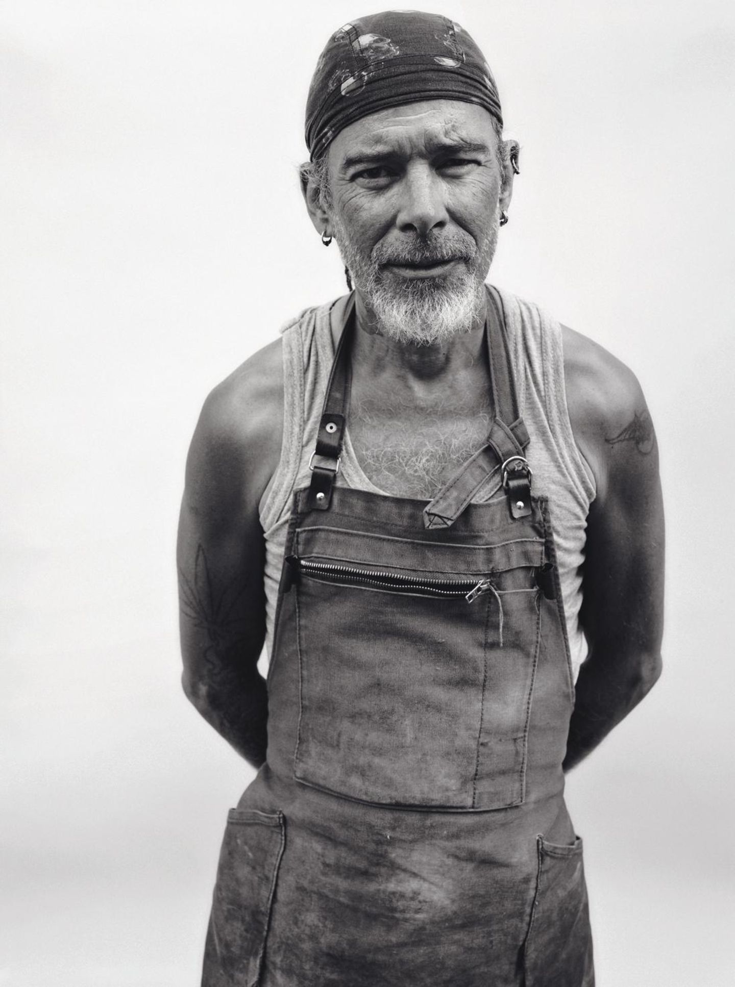 Ein alter Mann mit Stirnband und Jeansschürze