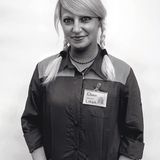 Eine blonde Frau mit zwei geflochtenen Zöpfen und einem Namensschild