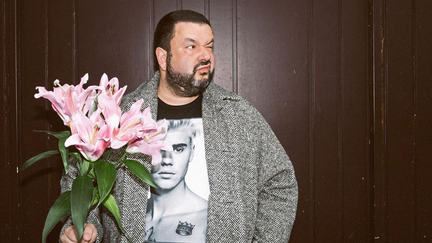 Oliver Polak mit einem Strauß Blumen und Justin Bieber T-Shirt