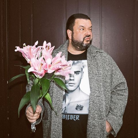 Oliver Polak mit einem Strauß Blumen und Justin Bieber T-Shirt