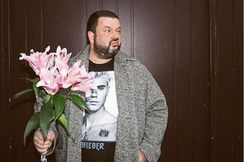 Oliver Polak mit einem Strauß Blumen und Justin Bieber T-Shirt