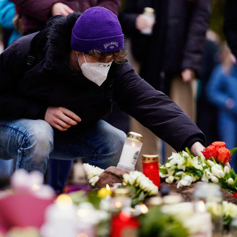 Am Tag nach dem Amoklauf in Heidelberg legen Menschen vor dem Uni-Gebäude Blumen und Kerzen ab