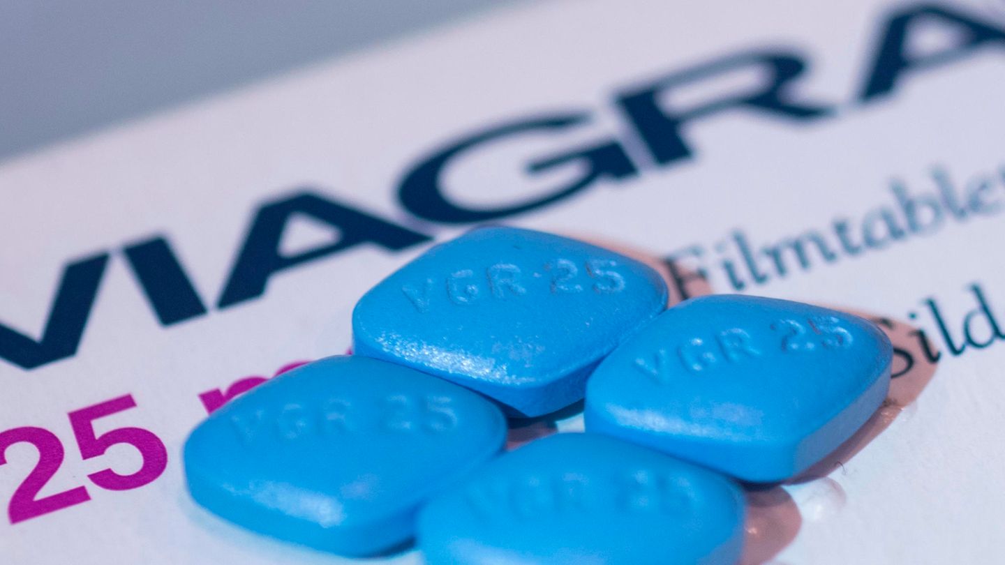Vier Viagra-Tabletten liegen auf einer Viagra-Packung