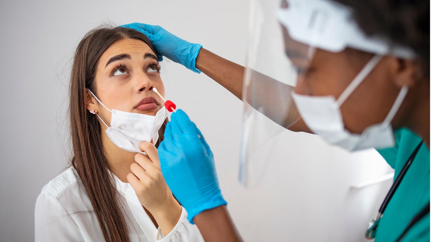 Eine Mitarbeiterin des Gesundheitswesens führt bei einer jungen Frau einen Corona-Test durch