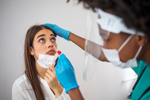 Eine Mitarbeiterin des Gesundheitswesens führt bei einer jungen Frau einen Corona-Test durch