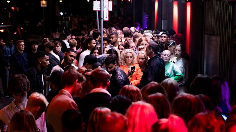 Menschen stehen dicht gedrängt und ohne Maske vor einem Nachtclub in Dänemark