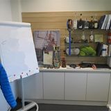 Büroausstattung mit Flipchart. Der Alkohol im Regal ist nicht im Angebot enthalten.