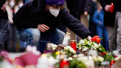 Ein junger Mann legt Blumen zu den Kerzen für die Opfer des Amoklaufs in Heidelberg