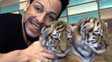 Glööckler posiert 2004 mit den Tigerbabys Dushan und Arnanka im Tierpark Berlin. Mit der Fotoaktion unterstützt er die Produktion eines Jahreskalenders für den Tierpark.