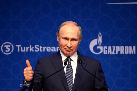 Russlands Präsident Wladimir Putin steht vor einem Podium und hält einen Daumen hoch