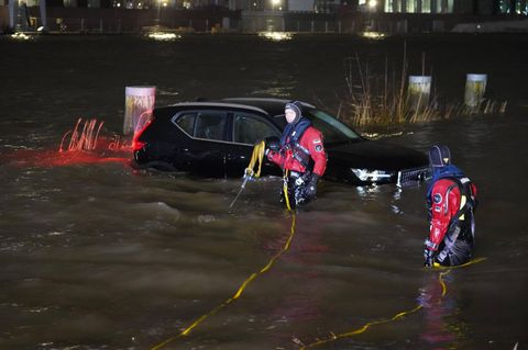 Einsatzkräfte der Feuerwehr ziehen in Hamburg Fahrzeuge aus dem Wasser. Sturmtief Nadia bescherte Hamburg eine Sturmflut.