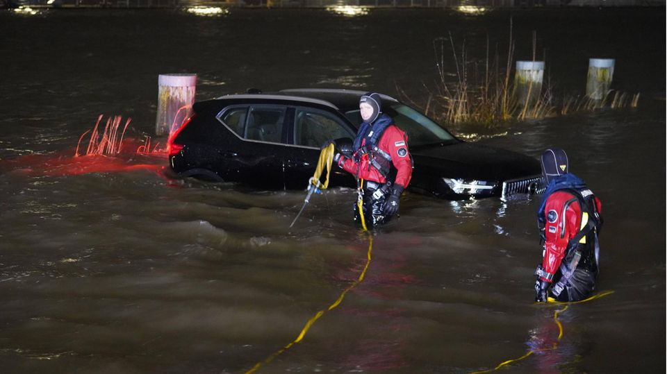 Einsatzkräfte der Feuerwehr ziehen in Hamburg Fahrzeuge aus dem Wasser. Sturmtief Nadia bescherte Hamburg eine Sturmflut.