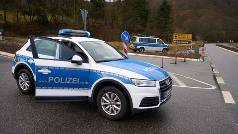 Polizeibeamte sperren die Zufahrt zum Tatort in Kusel