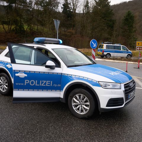 Polizeibeamte sperren die Zufahrt zum Tatort in Kusel