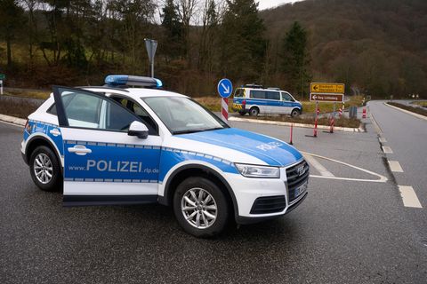 Polizeibeamte sperren die Zufahrt zum Tatort in Kusel