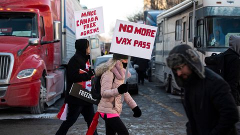 Zwei Demonstranten mit Schildern unterstützen den Trucker-Protest gegen die Corona-Regeln in Ottawa