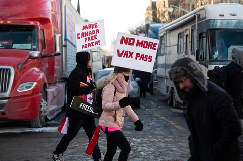 Zwei Demonstranten mit Schildern unterstützen den Trucker-Protest gegen die Corona-Regeln in Ottawa