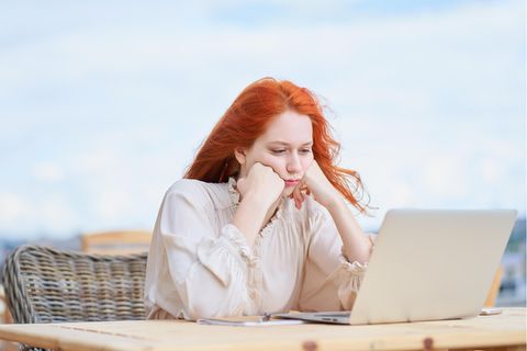 Frau sitzt frustriert vor ihrem Laptop