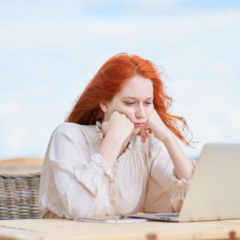 Frau sitzt frustriert vor ihrem Laptop