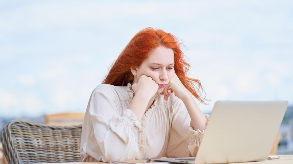 Frau sitzt frustriert vor ihrem Laptop
