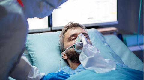 Mann mit Atemmaske im Krankenhaus