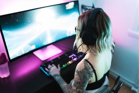 Ultrawide-Monitor: Eine Frau sitzt vor einem Ultrawide-Monitor und spielt daran.