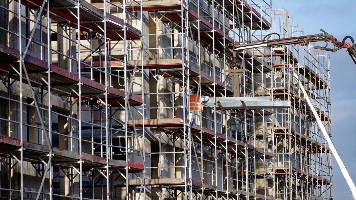 Eingerüstete, noch unfertige Neubauten stehen in einem Neubaugebiet in Hürth-Efferen. Nach dem plötzlichen KfW-Förderstopp bekommen viele Bauherren nun doch Geld für ihre energieeffizienten Häuser
