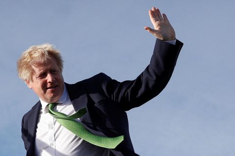 Boris Johnson winkt auf dem Weg in ein Flugzeug