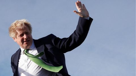 Boris Johnson winkt auf dem Weg in ein Flugzeug