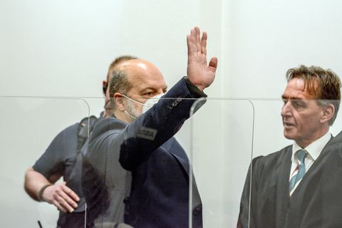 Thomas Drach winkt zum Auftakt des Prozesses in Richtung seines Mitangeklagten
