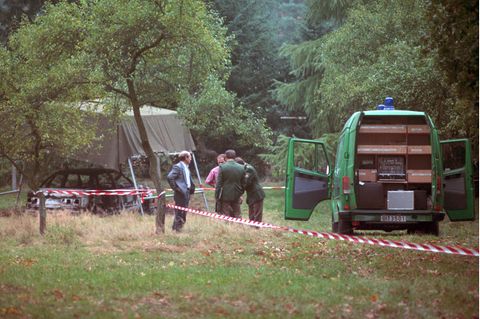 Polizeibeamte am 13.10.1991 bei der Spurensuche auf einem Waldparkplatz in Stukenbrock bei Bielefeld mit dem ausgebrannten Fahrzeug der vermissten Polizisten