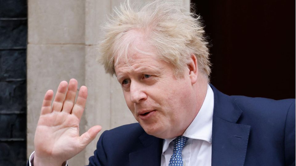 Großbritanniens Premier Boris Johnson mit vom Wind zerzaustem Haar winkt