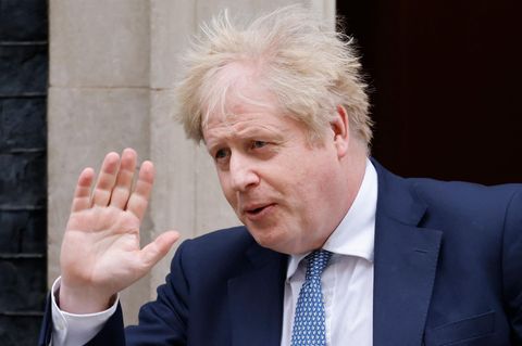 Großbritanniens Premier Boris Johnson mit vom Wind zerzaustem Haar winkt