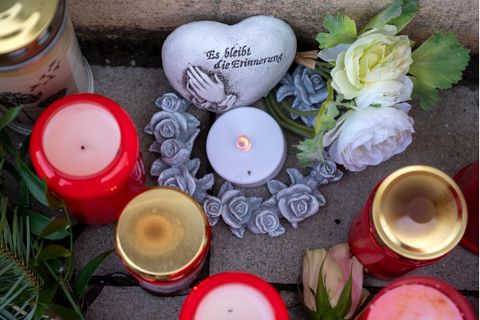 Blumen und Kerzen liegen vor der Polizeiinspektion in Kusel zum Gedenken