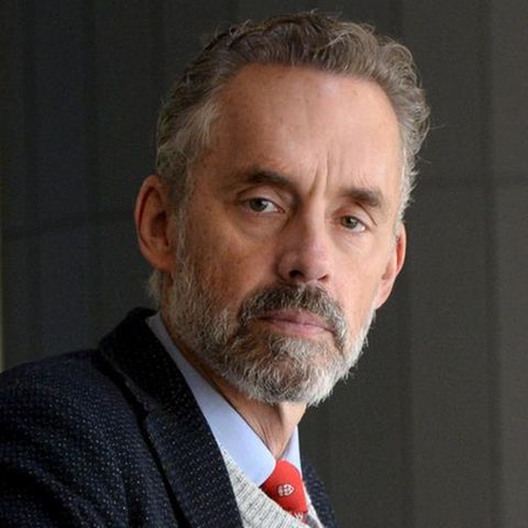 Jordan B. Peterson trägt Krawatte, Hemd und Sakko und schaut mit ernstem Blick in die Kamera