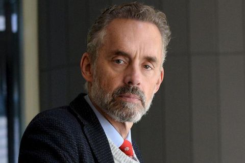 Jordan B. Peterson trägt Krawatte, Hemd und Sakko und schaut mit ernstem Blick in die Kamera