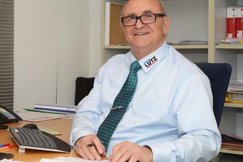 Lachender Mann mit Brille am Schreibtisch