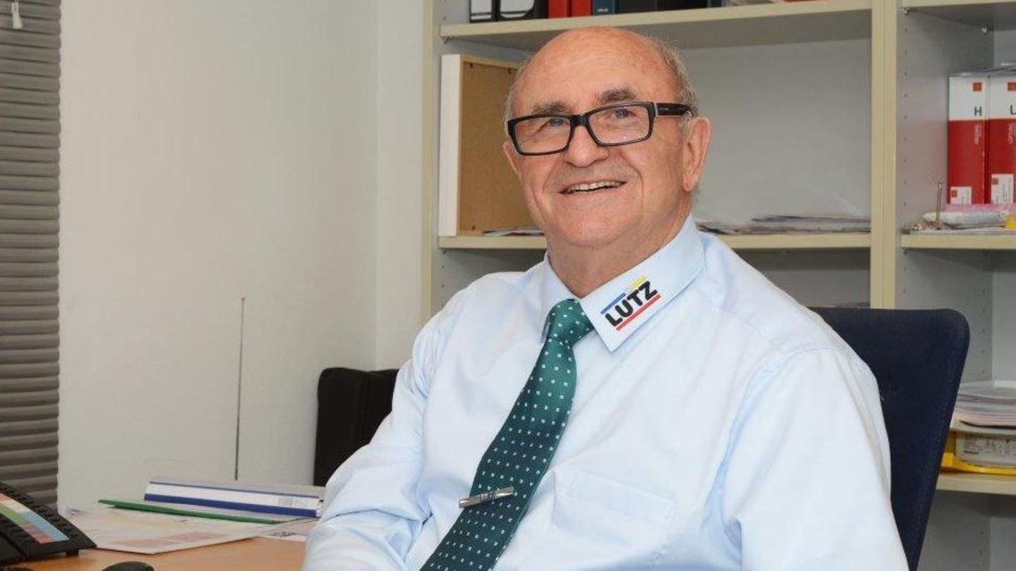 Lachender Mann mit Brille am Schreibtisch Lachender Mann mit Brille am Schreibtisch