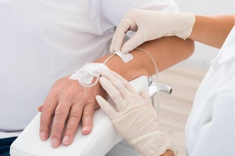 Doktor führt tropf in die Hand des Patienten ein