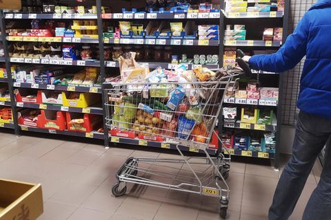 Kunde mit einem Einkaufswagen im Supermarkt