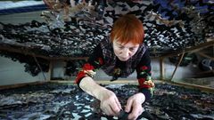 Eine Ukrainerin strickt eine Tarnnetz zur Unterstützung der Armee