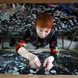 Eine Ukrainerin strickt eine Tarnnetz zur Unterstützung der Armee