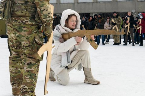 Eine Ukrainerin übt mit einem Holzgewehr