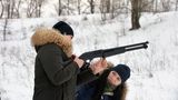 Junge Frauen üben mit einer Pump-Action-Schrotflinte