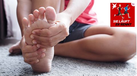 Laufen und Verletzungen: Eine Frau hält ihren schmerzenden Fuß