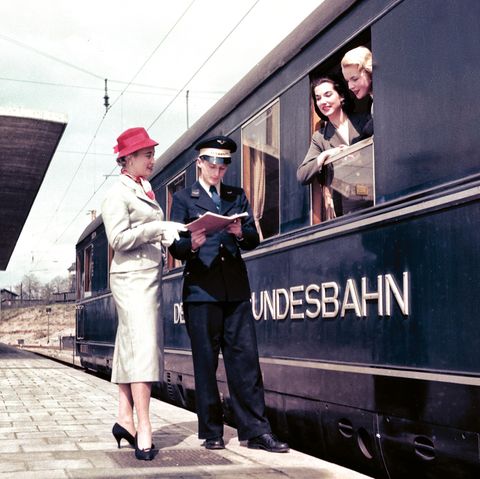 Werbemotiv der Bahn aus den späten 1950er Jahren: Fotomodelle am Fenster eines blauen Schürzenwagens für den Schnellzugverkehr  im Heidelberger Hauptbahnhof.