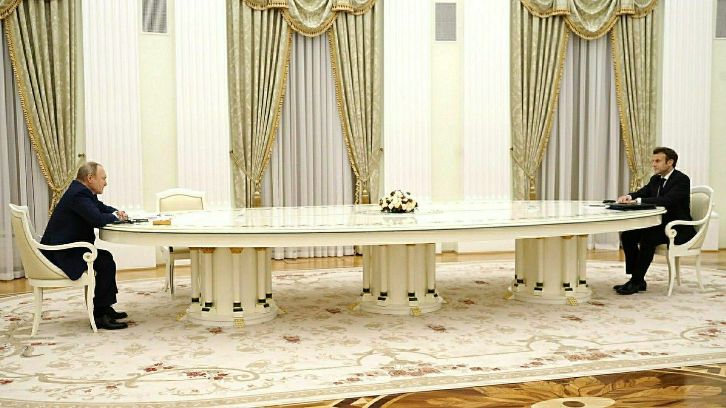 Putin und Macron sitzen sich an einem Tisch im Kreml in Moskau gegenüber