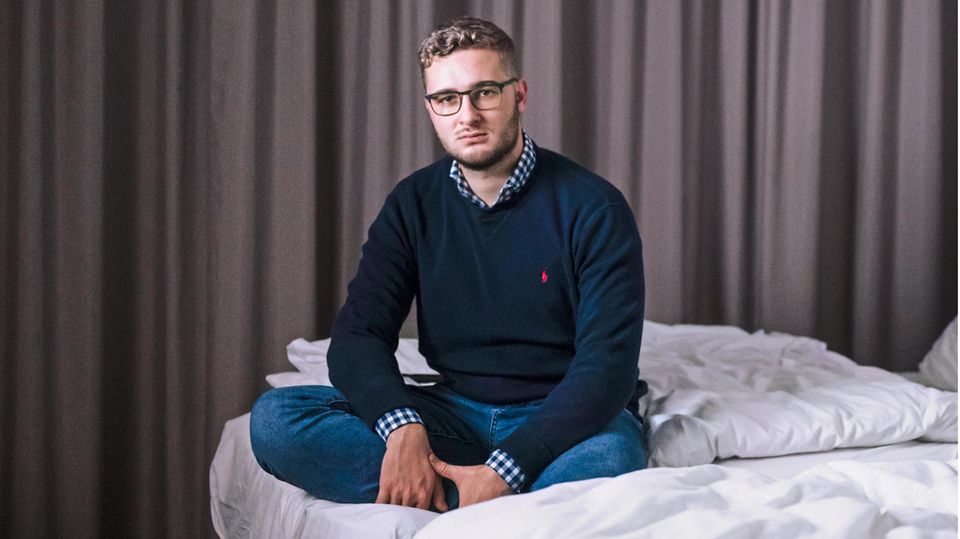 stern-Reporter Fabian Huber auf seinem Bett im Hotelzimmer