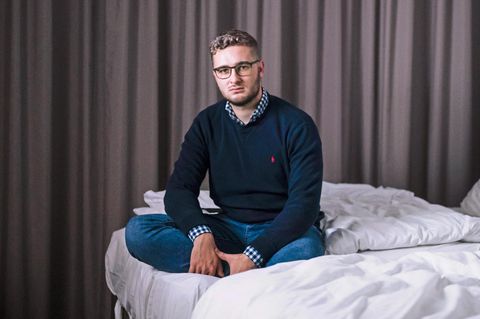 stern-Reporter Fabian Huber auf seinem Bett im Hotelzimmer
