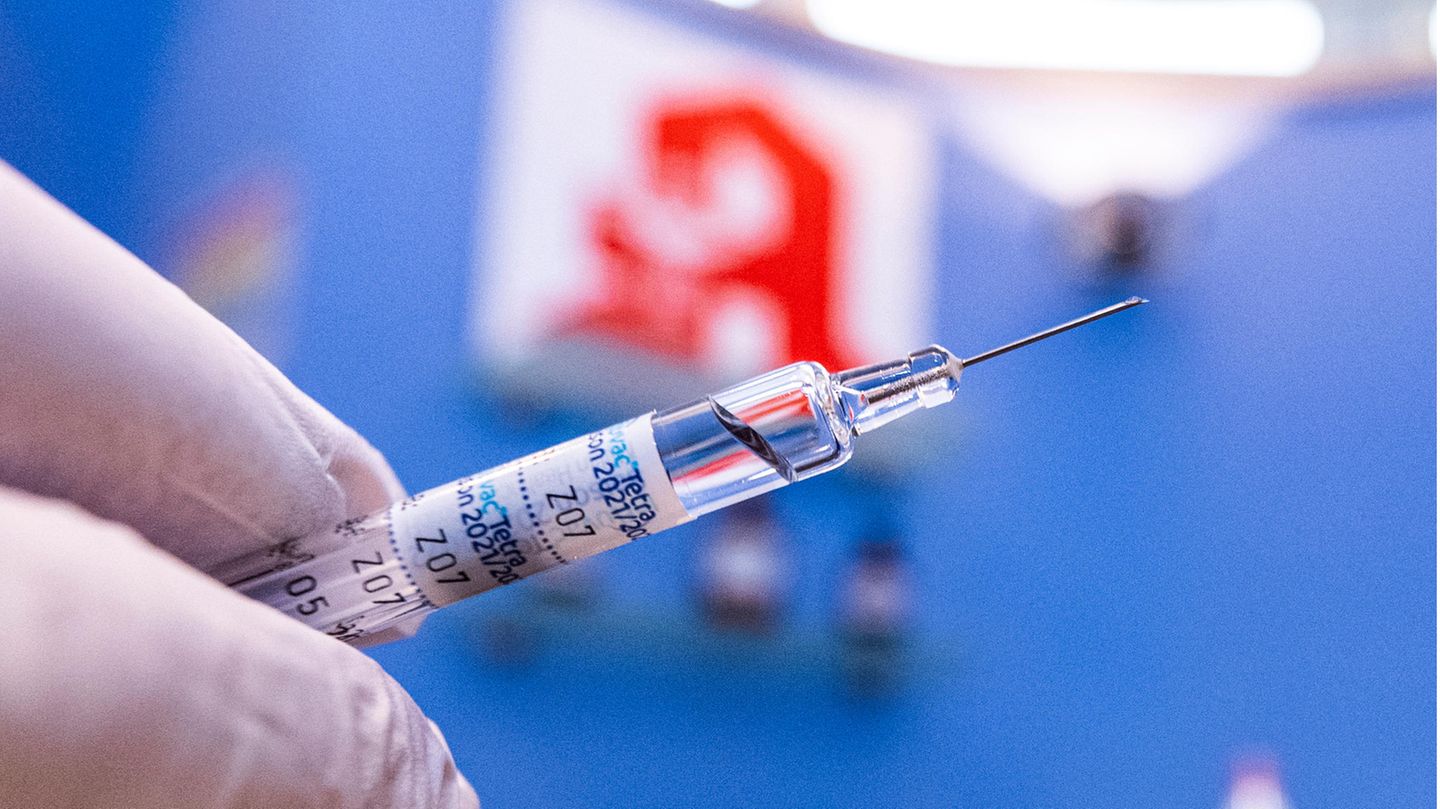 Spritze vor einem Apotheken-Logo